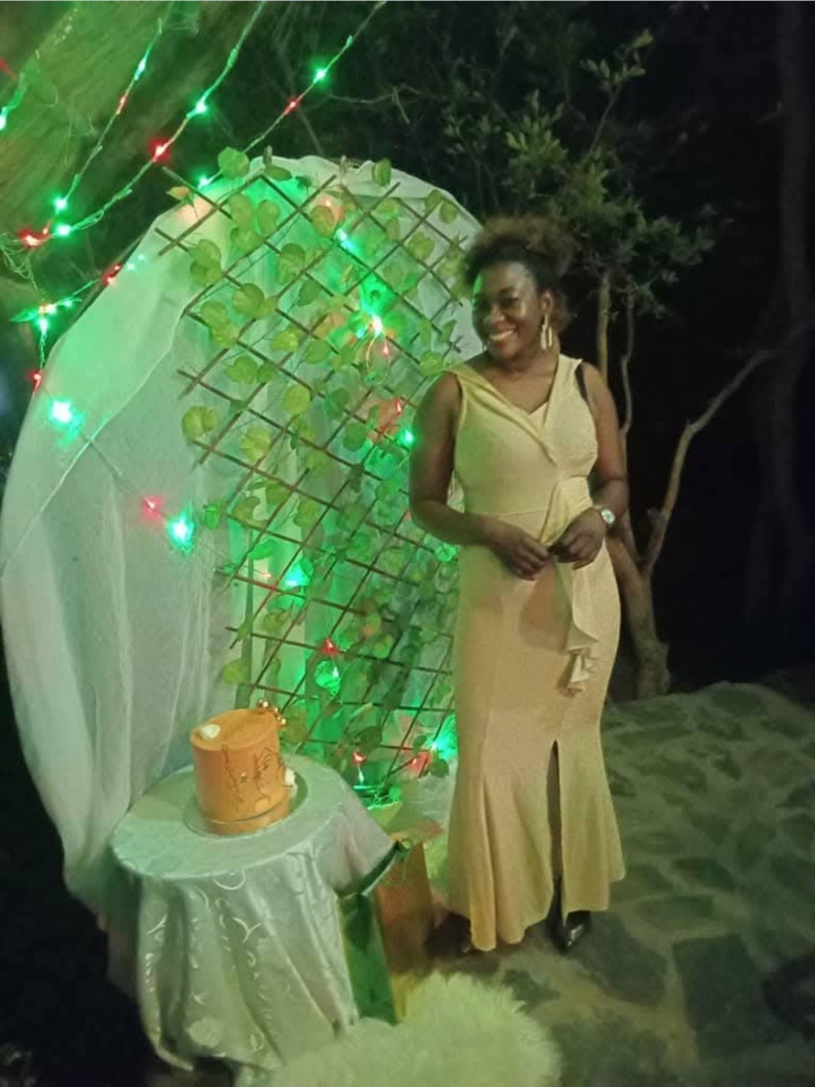 Lulu smiling beside a decorated celebration backdrop