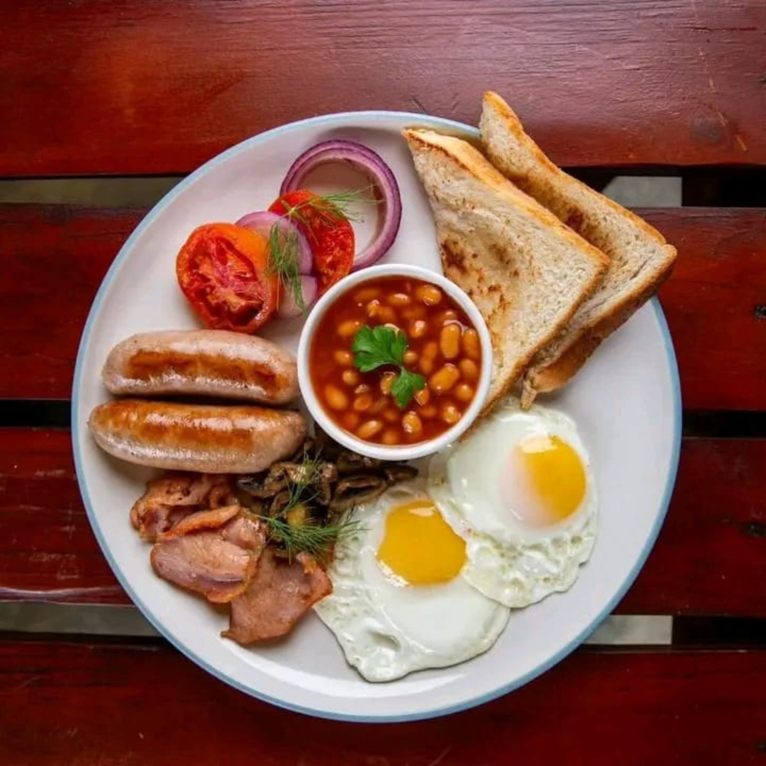 A breakfast plate with eggs, toast and beans.