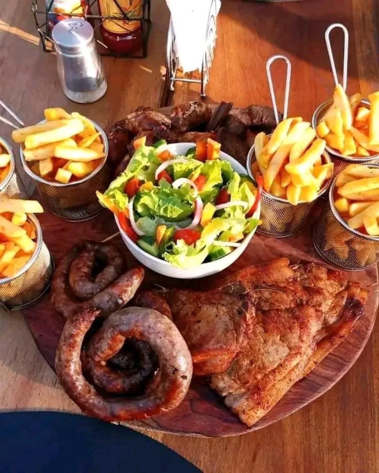 A generous spread of grilled meat, chips and salad.