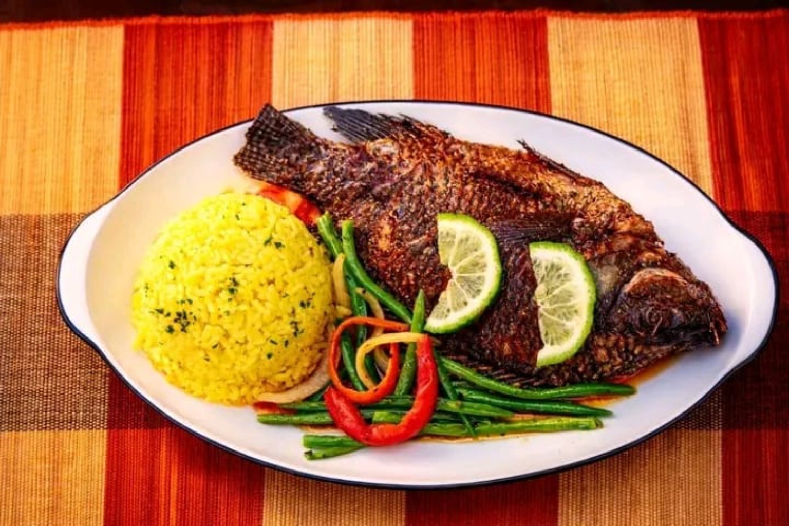 Whole fish served with rice and vegetables.